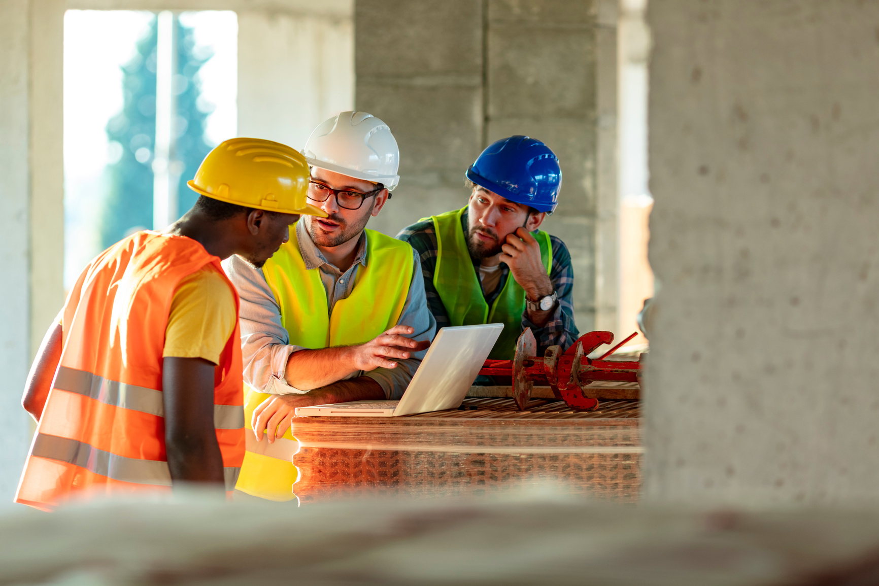 Construction workers using laptop on construction site